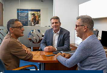 Two business owners meet with their relationship manager at an Eastern Bank branch