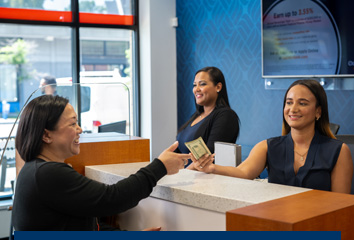 A customer conducts a transaction with a teller at an Eastern Bank branch