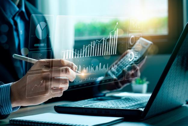 A person reviews their portfolio at their desk on their phone