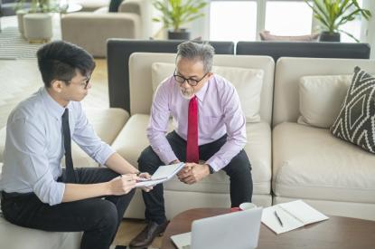 A father and son sit together and review finances