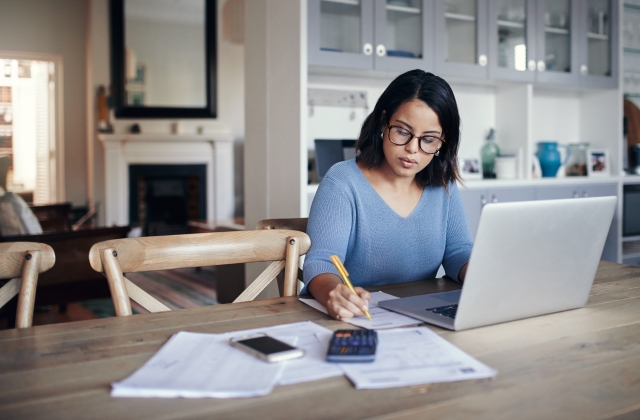 Women working on laptop and writing in notebook